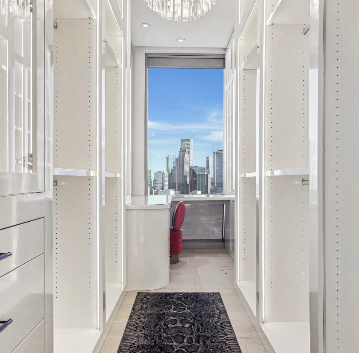 Illuminated white walk-in closet with a skyline view, The Residences at The Allen