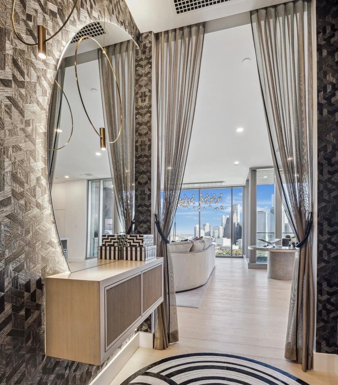 Entry foyer with patterned wallpaper, brass mirror and full-height curtains, The Residences at The Allen