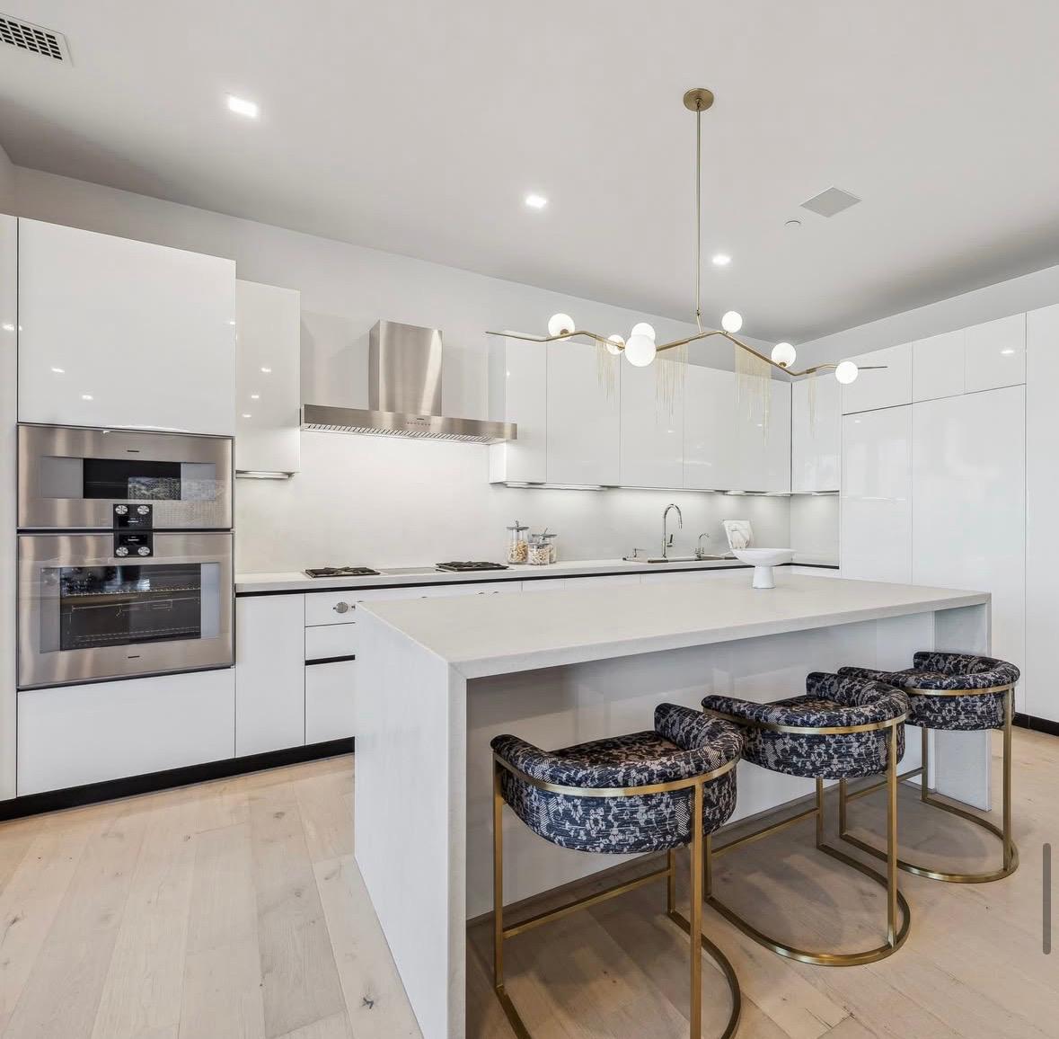White gloss kitchen with patterned stools and brass details, The Residences at The Allen
