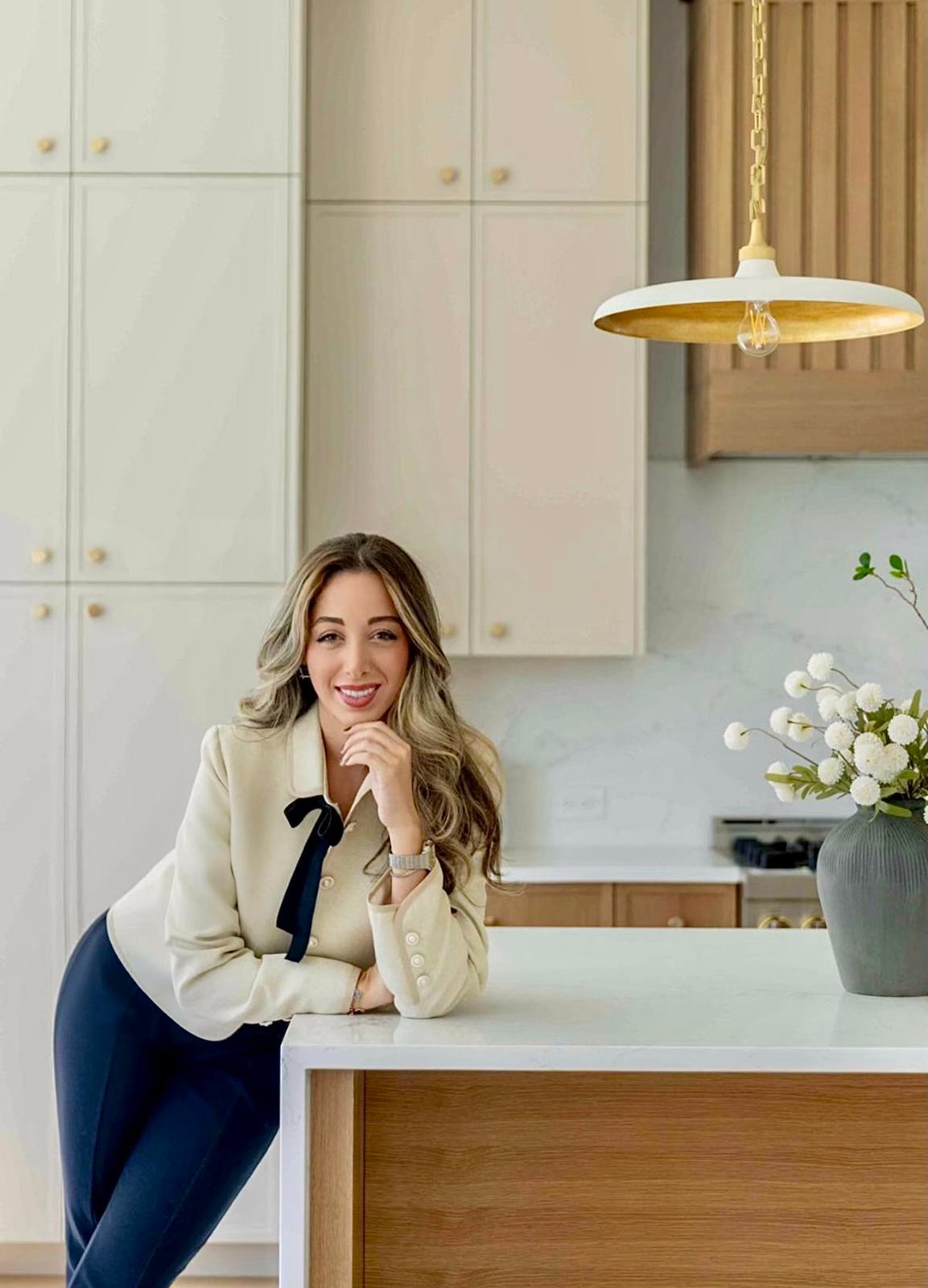 Athena, the designer behind Athena Studio, leaning on a kitchen island